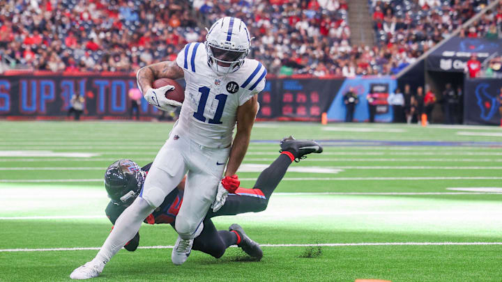Jan 4, 2026; Houston, Texas, USA; Indianapolis Colts wide receiver Michael Pittman Jr. (11) breaks Houston Texans cornerback Alijah Huzzie (36) tackle and dives for the end zone in the second half half at NRG Stadium.  