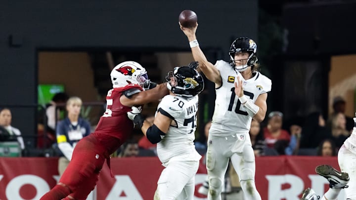 Nov 23, 2025; Glendale, Arizona, USA; Jacksonville Jaguars quarterback Trevor Lawrence (16) throws a pass as offensive lineman Cole Van Lanen (70) blocks Arizona Cardinals linebacker Zaven Collins (25) at State Farm Stadium. 