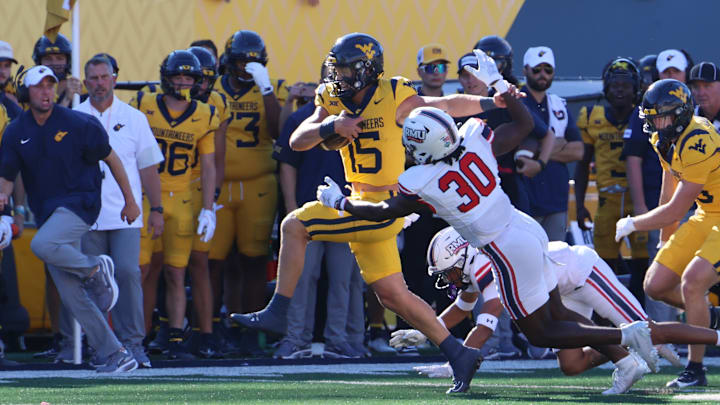 West Virginia University quarterback Scotty Fox Jr. breaks a tackle en route to a 59-yard touchdown run.
