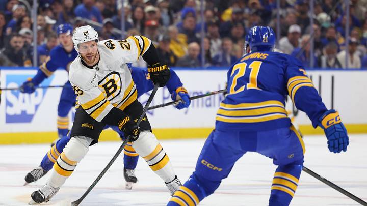 Apr 28, 2026; Buffalo, New York, USA; Boston Bruins center Elias Lindholm (28) looks to make a pass as Buffalo Sabres defenseman Conor Timmins (21) defends during the first period in game five of the first round of the 2026 Stanley Cup Playoffs at KeyBank Center. Mandatory Credit: Timothy T. Ludwig-Imagn Images