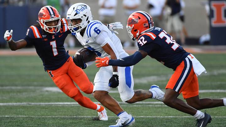 Sep 12, 2026; Champaign, Illinois, USA;  Duke Blue Devils wide receiver Jonah Burton (6) runs the ball past Illinois Fighting Illini defensive back Xavier Scott (1) and defensive back Tywan Cox (32) during the second half at Gies Memorial Stadium.  Mandatory Credit: Ron Johnson-Imagn Images