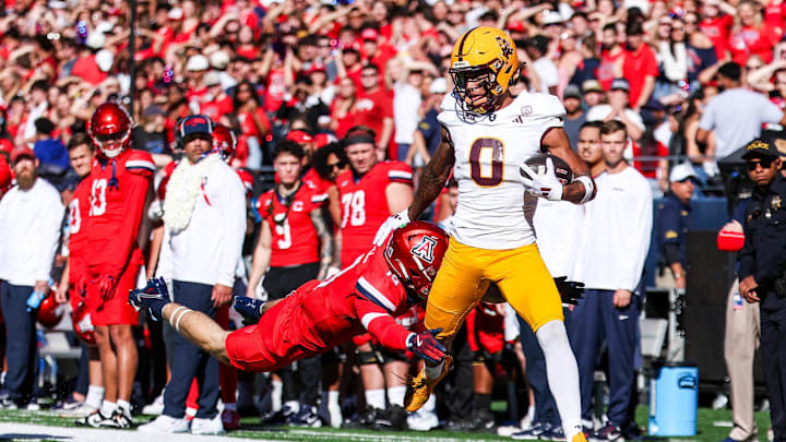 Nov 30, 2024; Tucson, Arizona, USA; Arizona Wildcats Jack Luttrell defensive back Jack Luttrell (13) tackles Arizona State Sun Devils wide receiver Jordyn Tyson (0) during the first half at Arizona Stadium. Mandatory Credit: Aryanna Frank-Imagn Images Nov 30, 2024; Tucson, Arizona, USA; Arizona Wildcats Jack Luttrell defensive back Jack Luttrell (13) tackles Arizona State Sun Devils wide receiver Jordyn Tyson (0) during the first half at Arizona Stadium. Mandatory Credit: Aryanna Frank-Imagn Images