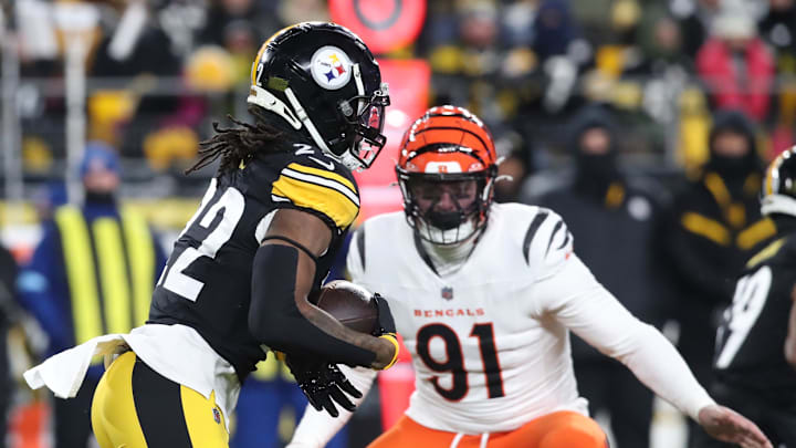 Jan 4, 2025; Pittsburgh, Pennsylvania, USA;  Pittsburgh Steelers running back Najee Harris (22) runs the ball as Cincinnati Bengals defensive end Trey Hendrickson (91) defends during the first quarter at Acrisure Stadium. Mandatory Credit: Charles LeClaire-Imagn Images