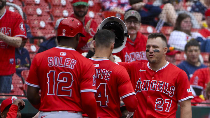 Apr 2, 2025; St. Louis, Missouri, USA;  Los Angeles Angels catcher Logan O'Hoppe (14) receives the fire helmet from right fielder Mike Trout (27) after hitting a grand slam against the St. Louis Cardinals during the seventh inning at Busch Stadium. Mandatory Credit: Jeff Curry-Imagn Images