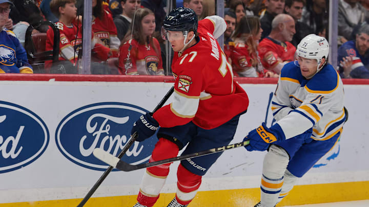 Feb 27, 2026; Sunrise, Florida, USA; Florida Panthers defenseman Niko Mikkola (77) moves the puck against Buffalo Sabres center Ryan McLeod (71) during the first period at Amerant Bank Arena. Mandatory Credit: Sam Navarro-Imagn Images
