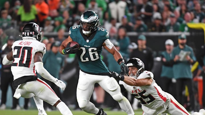 Philadelphia Eagles running back Saquon Barkley (26) tries to get way from Atlanta Falcons cornerback Dee Alford (20) and linebacker Kaden Elliss (55).