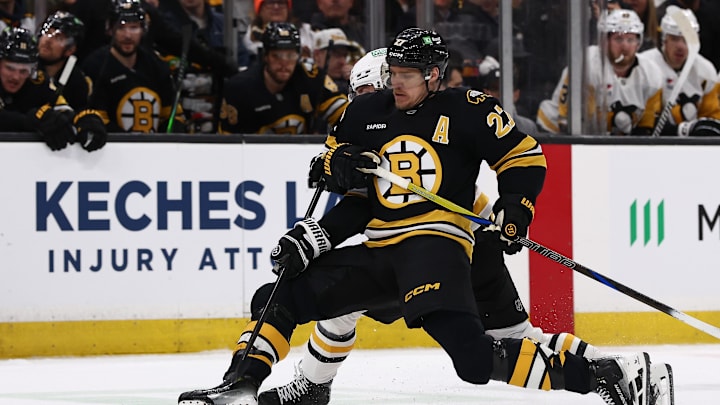 Mar 3, 2026; Boston, Massachusetts, USA; Boston Bruins defenseman Hampus Lindholm (27) holds off Pittsburgh Penguins center Connor Dewar (19) from getting to the puck during the first period at TD Garden. Mandatory Credit: Winslow Townson-Imagn Images