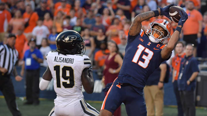 Oct 12, 2024; Champaign, Illinois, USA;  Illinois Fighting Illini wide receiver Pat Bryant (13) scores a touchdown catch over Purdue Boilermakers defensive back Botros Alisandro (19) in the second half at Memorial Stadium. Mandatory Credit: Ron Johnson-Imagn Images