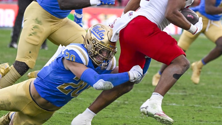 Nov 30, 2024; Pasadena, California, USA; UCLA Bruins linebacker Kain Medrano (20) tries to bring down Fresno State Bulldogs running back Bryson Donelson (26) during the third quarter at Rose Bowl. Mandatory Credit: Robert Hanashiro-Imagn Images