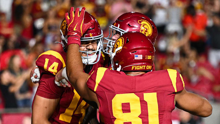 Sep 7, 2024; Los Angeles, California, USA; USC Trojans quarterback Jayden Maiava (14) celebrates with teammates after scoring a touchdown against the Utah State Aggies during the fourth quarter at United Airlines Field at Los Angeles Memorial Coliseum. Mandatory Credit: Jonathan Hui-Imagn Images