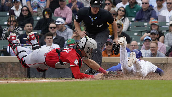 Sep 27, 2024; Chicago, Illinois, USA; Chicago Cubs second baseman Nico Hoerner (2) is safe at home as Cincinnati Reds catcher Tyler Stephenson (37) makes a late tag during the fifth inning plate at Wrigley Field. Mandatory Credit: David Banks-Imagn Images