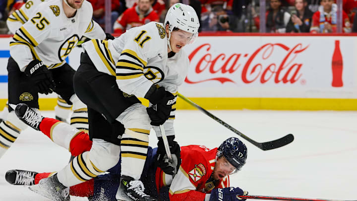 May 8, 2024; Sunrise, Florida, USA; Florida Panthers center Evan Rodrigues (17) dives for the puck against Boston Bruins center Trent Frederic (11) during the first period in game two of the second round of the 2024 Stanley Cup Playoffs at Amerant Bank Arena. Mandatory Credit: Sam Navarro-Imagn Images