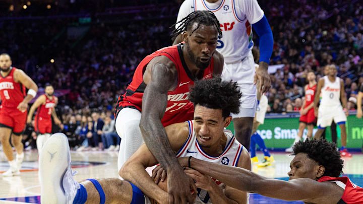 Nov 27, 2024; Philadelphia, Pennsylvania, USA; Philadelphia 76ers guard Jared McCain (20) controls a loose ball against Houston Rockets forward Tari Eason (17) and forward Amen Thompson (1) during the fourth quarter at Wells Fargo Center. Mandatory Credit: Bill Streicher-Imagn Images