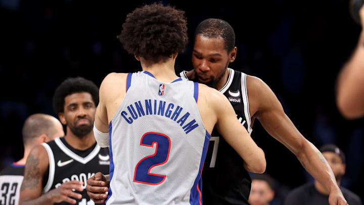 Mar 29, 2022; Brooklyn, New York, USA; Detroit Pistons guard Cade Cunningham (2) hugs Brooklyn Nets forward Kevin Durant (7) in front of Nets guard Kyrie Irving (11) after their game at Barclays Center. The Nets defeated the Pistons 130-123. Mandatory Credit: Brad Penner-Imagn Images