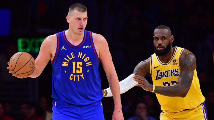 Apr 25, 2024; Los Angeles, California, USA; Denver Nuggets center Nikola Jokic (15) dribbles against Los Angeles Lakers forward LeBron James (23).