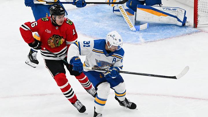 Oct 6, 2026; Chicago, Illinois, USA;  Chicago Blackhawks center Anton Frondell (16) and St. Louis Blues left wing Dylan Holloway (81) chase the puck during the second period at United Center.  Mandatory Credit: Matt Marton-Imagn Images
