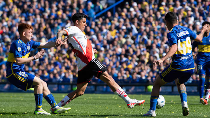 Valentin Barco (L) of Boca Juniors is seen in action with...