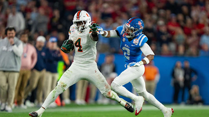 Miami Hurricanes running back Mark Fletcher Jr. (4) runs the ball as Ole Miss cornerback Jaylon Braxton (2) tries to tackle him during the CFP Fiesta Bowl at the State Farm Stadium, in Glendale, Ariz., on Thursday, Jan. 8, 2026.