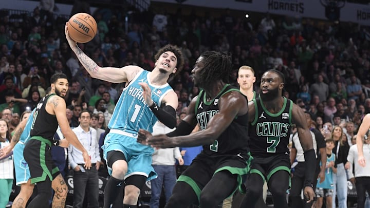 Charlotte Hornets guard LaMelo Ball (1) drives in as he is defended by Boston Celtics guard Jrue Holiday (4)  during the second half at the Spectrum Center. Mandatory Credit: Sam Sharpe-Imagn Images