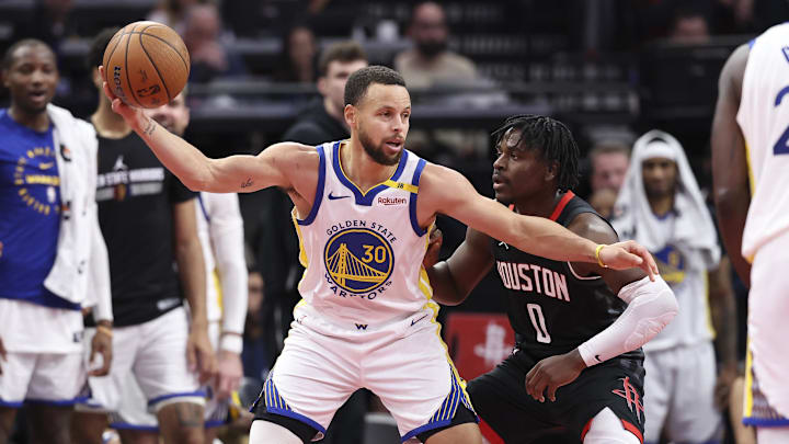 Dec 11, 2024; Houston, Texas, USA; Golden State Warriors guard Stephen Curry (30) controls the ball as Houston Rockets guard Aaron Holiday (0) defends during the fourth quarter at Toyota Center. Mandatory Credit: Troy Taormina-Imagn Images