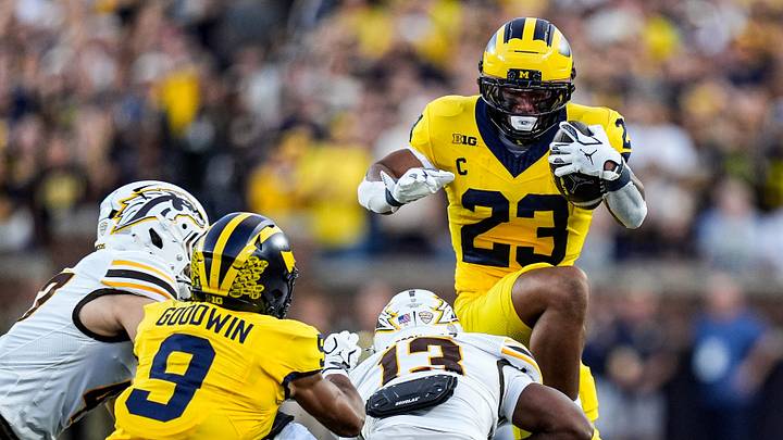 Michigan running back Jordan Marshall (23) jumps over Western Michigan cornerback Jordon Thomas (13) during the first half at Michigan Stadium in Ann Arbor on Saturday, Sept. 5, 2026. Michigan running back Jordan Marshall (23) jumps over Western Michigan cornerback Jordon Thomas (13) during the first half at Michigan Stadium in Ann Arbor on Saturday, Sept. 5, 2026.