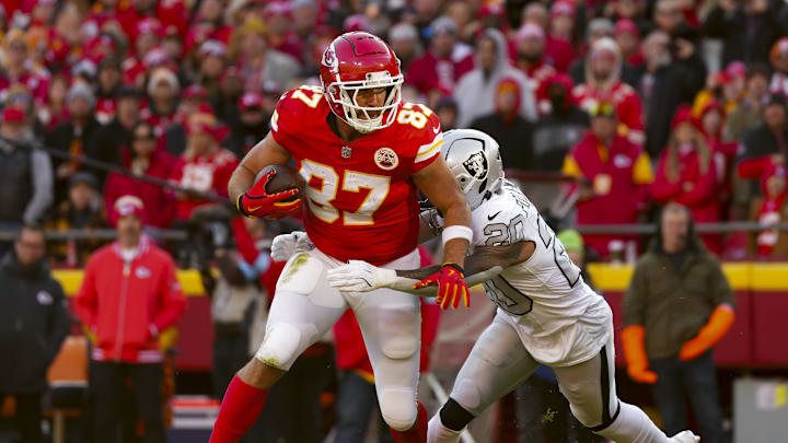 Nov 29, 2024; Kansas City, Missouri, USA; Kansas City Chiefs tight end Travis Kelce (87) runs with the ball against Las Vegas Raiders safety Isaiah Pola-Mao (20) during the first half at GEHA Field at Arrowhead Stadium. Mandatory Credit: Jay Biggerstaff-Imagn Images