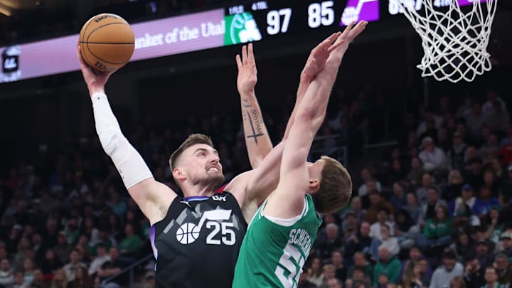 Mar 21, 2025; Salt Lake City, Utah, USA; Utah Jazz center Micah Potter (25) goes for a dunk against Boston Celtics forward Baylor Scheierman (55) during the second half at Delta Center. Mandatory Credit: Rob Gray-Imagn Images