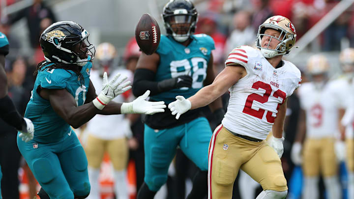 Jacksonville Jaguars linebacker Devin Lloyd (L) and San Francisco 49ers running back Christian McCaffrey (R)