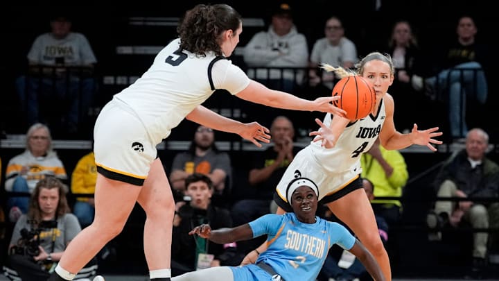Iowa center Ava Heiden (5) passes the ball to Iowa guard Kylie Feuerbach (4) over Southern guard Jaylia Reed (2) Nov. 3, 2025 during a women’s college basketball game at Carver-Hawkeye Arena in Iowa City, Iowa.