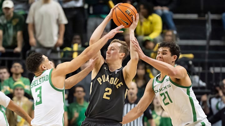 Oregon forward Brandon Angel, right, and guard Jackson Shelstad, left, attempt to foul Purdue guard Fletcher Loyer in the final moments of the game as the Oregon Ducks host the Purdue Boilermakers Saturday, Jan. 18, 2025, at Matthew Knight Arena in Eugene, Ore.