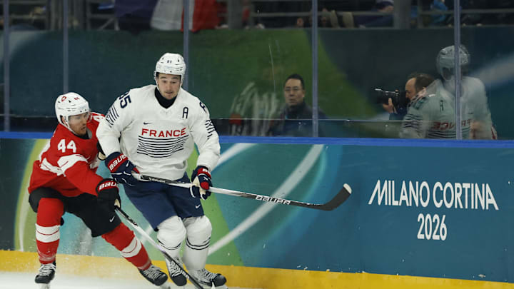 Feb 12, 2026; Milan, Italy; Alexandre Texier of France in action with Pius Suter of Switzerla during a Group A men's ice hockey game during the Milano Cortina 2026 Olympic Winter Games at Milano Santagiulia Ice Hockey Arena. Mandatory Credit: Geoff Burke-Imagn Images