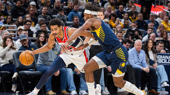 Jan 10, 2024; Indianapolis, Indiana, USA; Washington Wizards guard Jordan Poole (13) dribbles the ball while Indiana Pacers guard Buddy Hield (7) defends in the first half at Gainbridge Fieldhouse. Mandatory Credit: Trevor Ruszkowski-Imagn Images