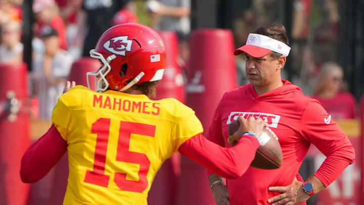 Jul 26, 2024; Kansas City, MO, USA; Kansas City Chiefs quarterback Patrick Mahomes (15) throws a pass as general manager Brett Veach watches in the background during training camp at Missouri Western State University. Mandatory Credit: Denny Medley-Imagn Images