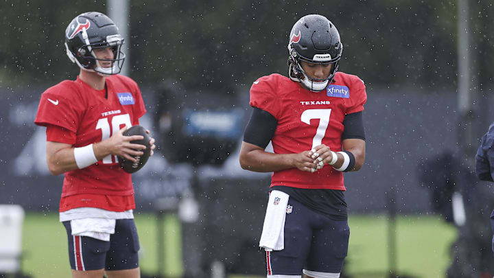 Jul 27, 2024; Houston, TX, USA; Houston Texans quarterback C.J. Stroud (7) tapes his hand as quarterback Davis Mills (10) looks on during training camp at Houston Methodist Training Center. Jul 27, 2024; Houston, TX, USA; Houston Texans quarterback C.J. Stroud (7) tapes his hand as quarterback Davis Mills (10) looks on during training camp at Houston Methodist Training Center.