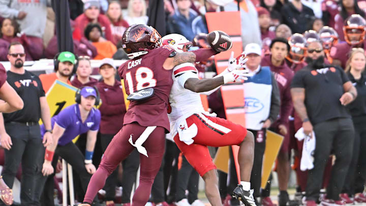 Nov 1, 2025; Blacksburg, Virginia, USA;  .Virginia Tech Hokies safety Isaiah Cash (18) makes a defensive play as Louisville Cardinals wide receiver Caullin Lacy (5) attempts to catch a pass during the fourth quarter at Lane Stadium. Mandatory Credit: Brian Bishop-Imagn Images