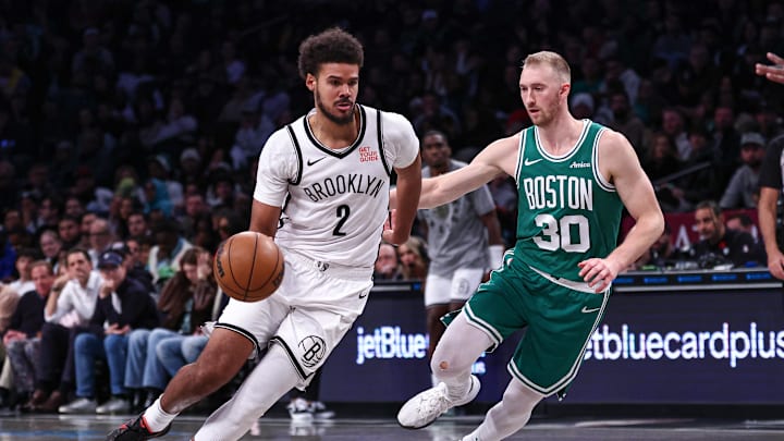 Nov 13, 2024; Brooklyn, New York, USA; Brooklyn Nets forward Cameron Johnson (2) dribbles as Boston Celtics forward Sam Hauser (30) defends during the second half at Barclays Center. Mandatory Credit: Vincent Carchietta-Imagn Images