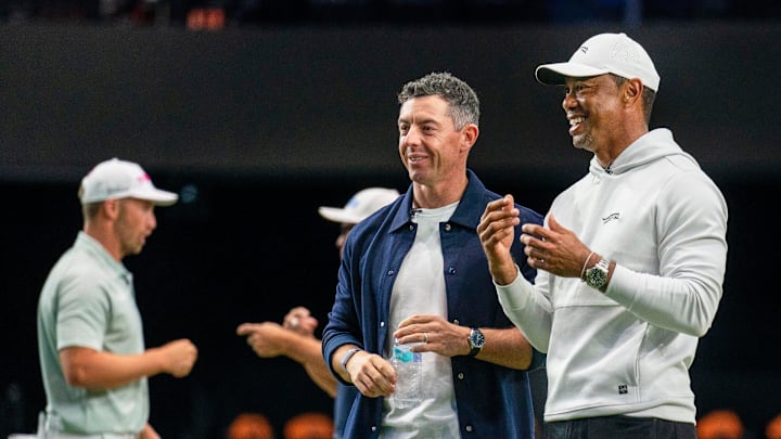 Rory McIlroy and Tiger Woods watch golfers warm up for the inaugural match at SoFi Center, the home of TGL, the interactive golf league founded by Woods and McIlroy on January 7, 2025 in Palm Beach Gardens, Florida.