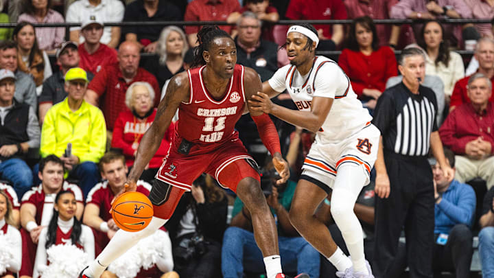 Feb 15, 2025; Tuscaloosa, Alabama, USA; Alabama Crimson Tide center Clifford Omoruyi (11) controls the ball as Auburn Tigers guard Denver Jones (2) defends during the first half at Coleman Coliseum. Mandatory Credit: Will McLelland-Imagn Images