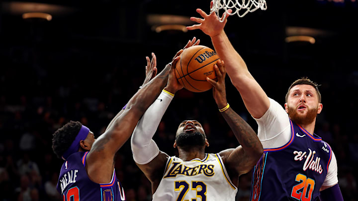 Feb 25, 2024; Phoenix, Arizona, USA; Los Angeles Lakers forward LeBron James (23) shoots the ball against Phoenix Suns forward Royce O'Neale (00) and center Jusuf Nurkic (20) during the fourth quarter at Footprint Center. Mandatory Credit: Mark J. Rebilas-Imagn Images