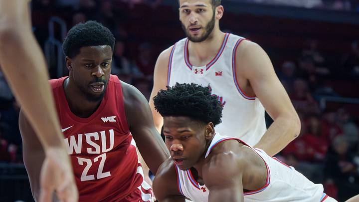 Bradley’s Jaquan Johnson, right, tries to move the ball against ND Okafor (22) and the Washington State defense in the first half of their college basketball game Tuesday, Dec. 2, 2025 at Carver Arena in Peoria. The Braves rallied for a 64-60 victory.
