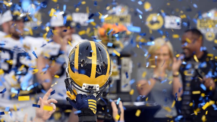 Jan 1, 2016; Orlando, FL, USA;  Michigan Wolverines player raises his helmet during the celebration of defeating Florida Gators 41-7 to earn the 2016 Citrus Bowl championship at Orlando Citrus Bowl Stadium. Michigan Wolverines defeated Florida Gators 41-7. Mandatory Credit: Tommy Gilligan-Imagn Images