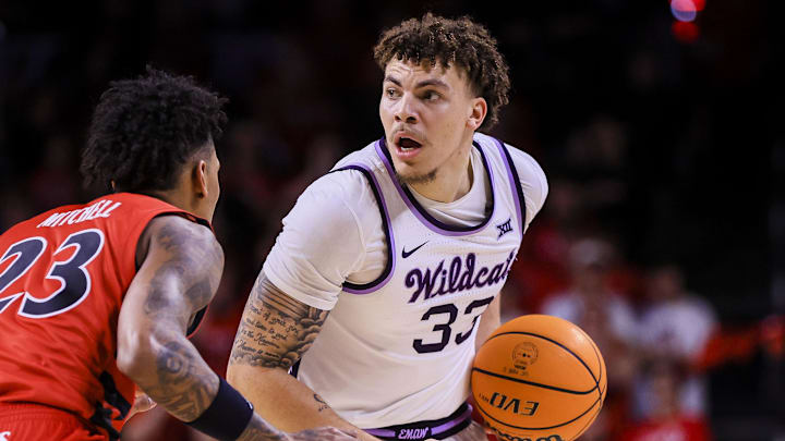 Mar 5, 2025; Cincinnati, Ohio, USA; Kansas State Wildcats guard Coleman Hawkins (33) holds the ball against Cincinnati Bearcats forward Dillon Mitchell (23) in the second half at Fifth Third Arena. Mandatory Credit: Katie Stratman-Imagn Images
