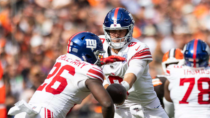 Sep 22, 2024; Cleveland, Ohio, USA; New York Giants quarterback Daniel Jones (8) hands the ball off to running back Devin Singletary (26) during the fourth quarter against the Cleveland Browns at Huntington Bank Field. Sep 22, 2024; Cleveland, Ohio, USA; New York Giants quarterback Daniel Jones (8) hands the ball off to running back Devin Singletary (26) during the fourth quarter against the Cleveland Browns at Huntington Bank Field.