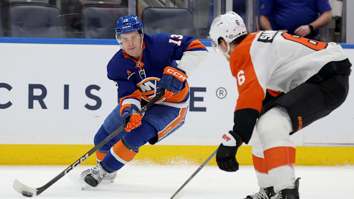 Jan 24, 2025; Elmont, New York, USA; New York Islanders center Mathew Barzal (13) controls the puck against Philadelphia Flyers defenseman Travis Sanheim (6) during the second period at UBS Arena. 