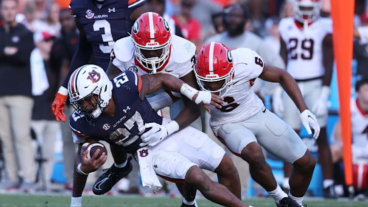 Sep 30, 2023; Auburn, Alabama, USA;  Auburn Tigers running back Jarquez Hunter (27) is tackled by Georgia Bulldogs linebacker C.J. Allen (33) and defensive back Daylen Everette (6) during the third quarter at Jordan-Hare Stadium. Mandatory Credit: John Reed-Imagn Images