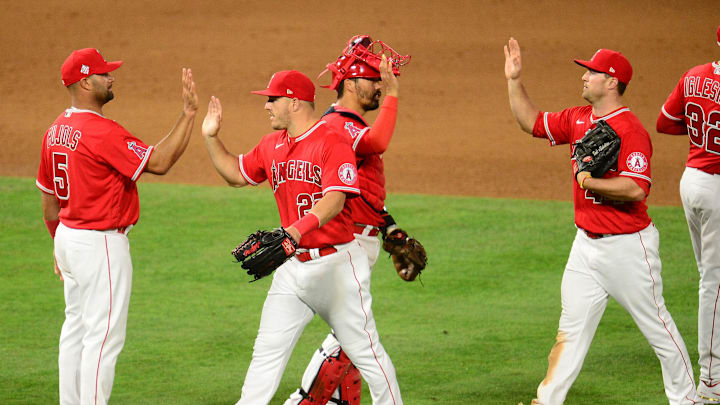 Apr 20, 2021; Anaheim, California, USA; Los Angeles Angels designated hitter Albert Pujols (5) center fielder Mike Trout (27) catcher Kurt Suzuki (24) and right fielder Scott Schebler (44) celebrate the 6-2 victory against the Texas Rangers  at Angel Stadium. Mandatory Credit: Gary A. Vasquez-Imagn Images