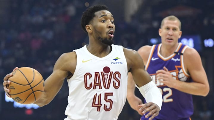 Jan 20, 2025; Cleveland, Ohio, USA; Cleveland Cavaliers guard Donovan Mitchell (45) drives to the basket beside Phoenix Suns center Mason Plumlee (22) in the first quarter at Rocket Mortgage FieldHouse. Mandatory Credit: David Richard-Imagn Images