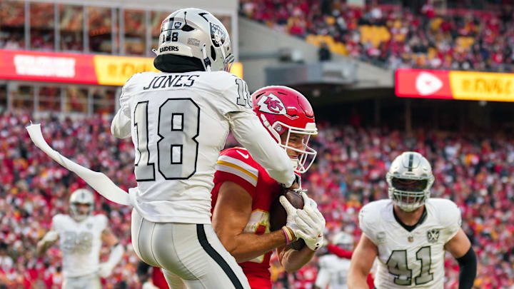 Nov 29, 2024; Kansas City, Missouri, USA; Kansas City Chiefs wide receiver Justin Watson (84) catches a touchdown pass against Las Vegas Raiders cornerback Jack Jones (18) during the first half at GEHA Field at Arrowhead Stadium. Mandatory Credit: Jay Biggerstaff-Imagn Images
