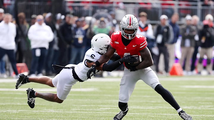 Nov 1, 2025; Columbus, Ohio, USA;  Ohio State Buckeyes wide receiver Jeremiah Smith (4) runs with the ball as Penn State Nittany Lions safety Zakee Wheatley (6) makes the tackle during the first quarter at Ohio Stadium. Mandatory Credit: Joseph Maiorana-Imagn Images