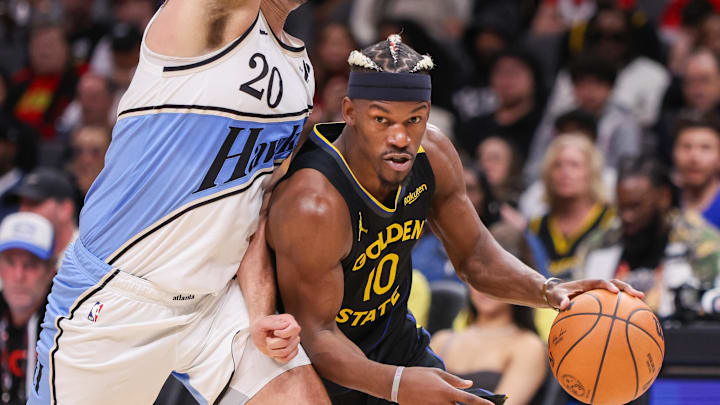 Mar 22, 2025; Atlanta, Georgia, USA; Golden State Warriors forward Jimmy Butler III (10) drives on Atlanta Hawks forward Georges Niang (20) in the fourth quarter at State Farm Arena. Mandatory Credit: Brett Davis-Imagn Images